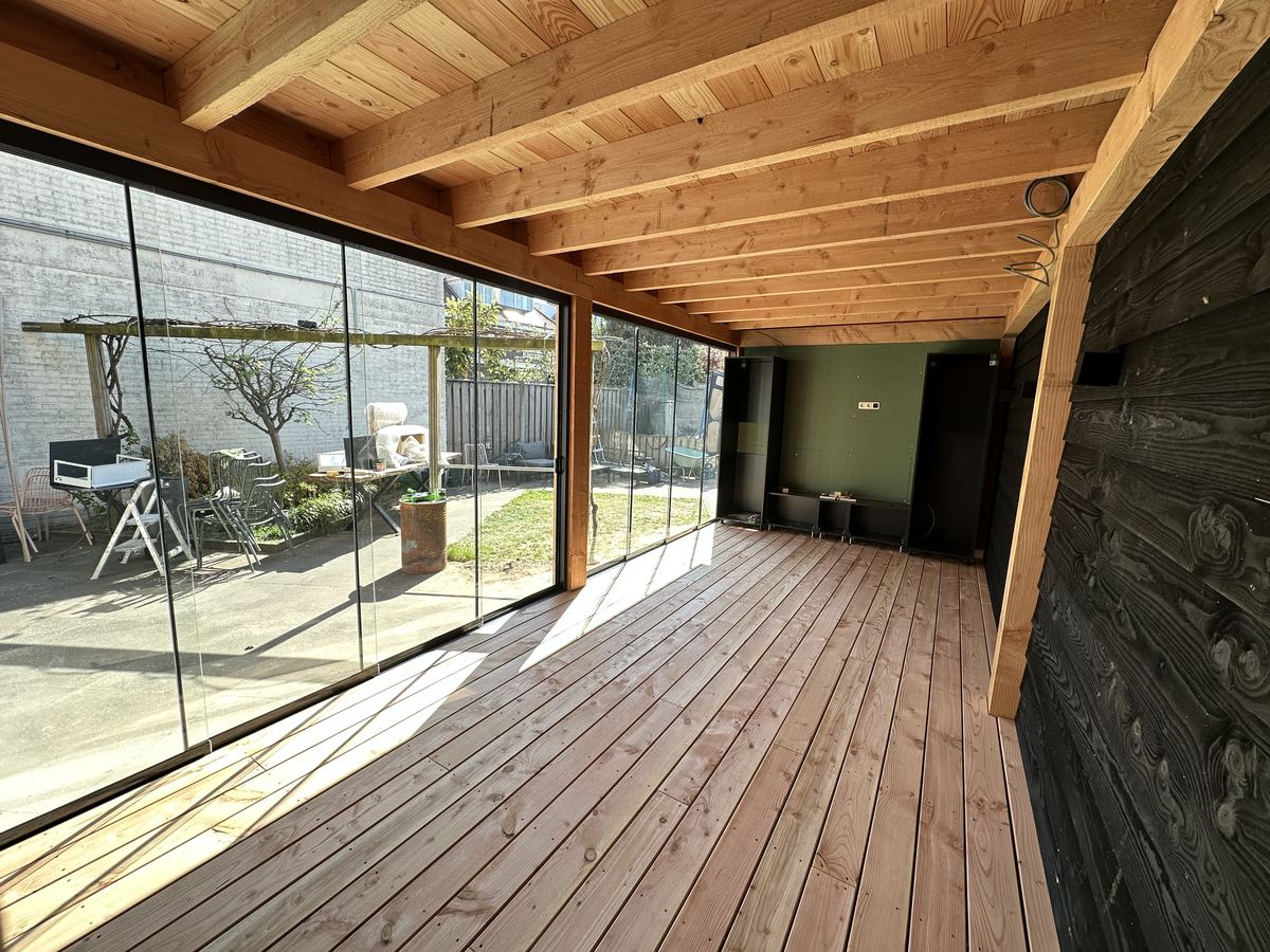Interieur buitenkamer met glazen wanden en uitzicht op tuin