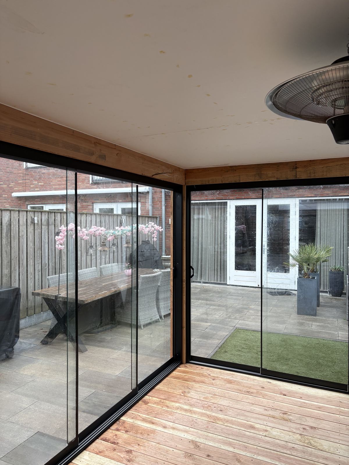 Binnenzicht glazen schuifwanden met doorkijk naar tuin