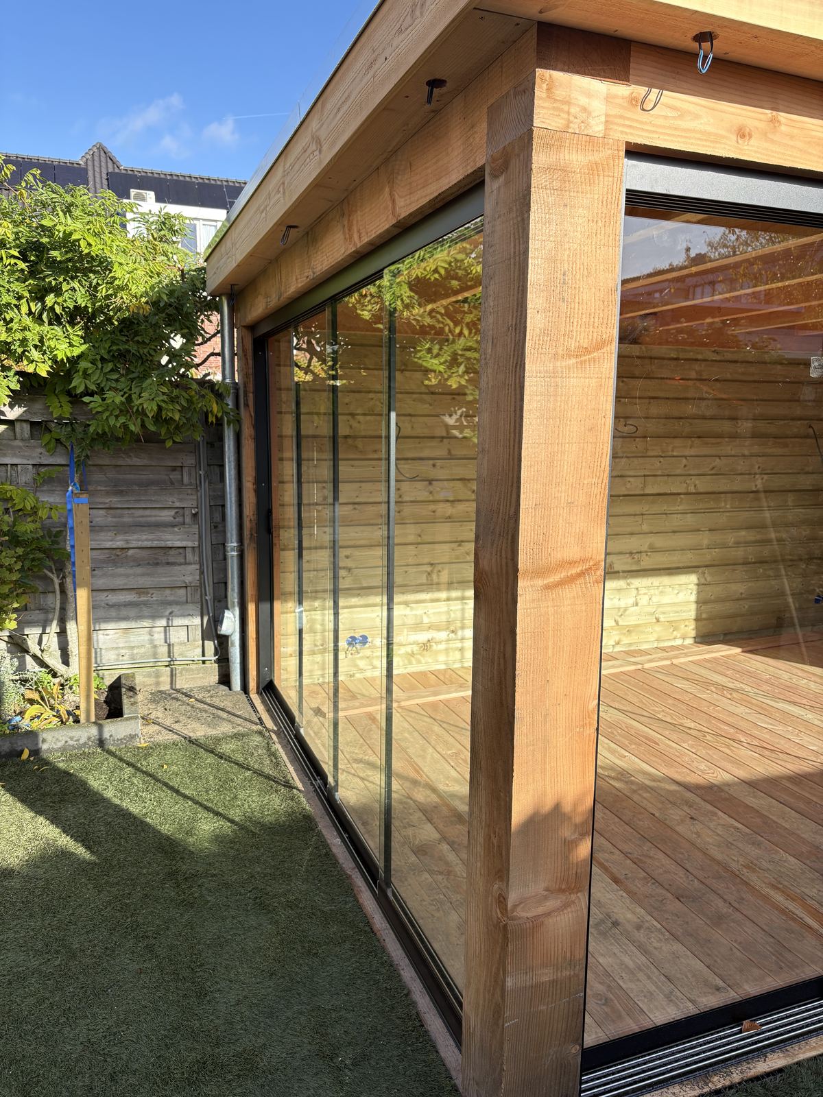 Close-up glazen schuifwand bij houten overkapping